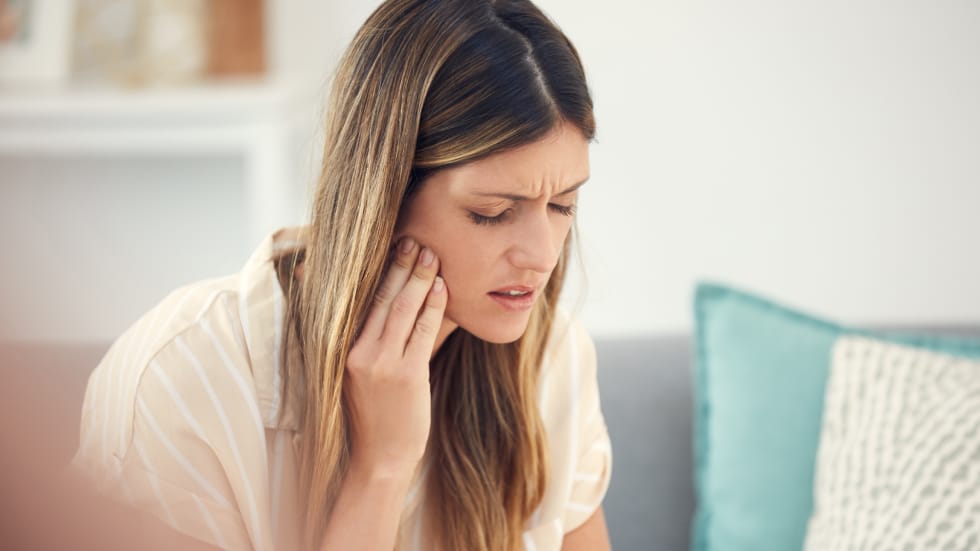 A parent experiencing a painful dental emergency or severe toothache, highlighting the importance of family dental care in Oshawa.