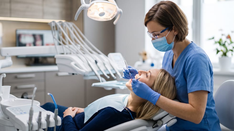 Dental hygienist performing a routine teeth cleaning and scaling appointment at a dental clinic in Oshawa.