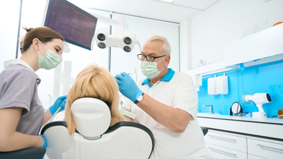 Dentist and assistant providing comprehensive dental care to a patient at King Ritson Dental Clinic in Oshawa.